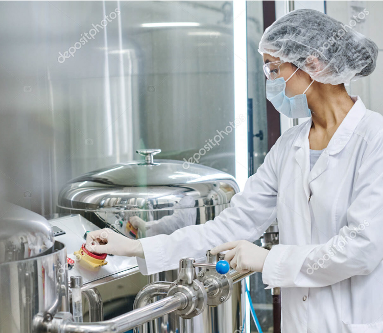 1 Operator or auditor in a clean room operating controls on a stainless steel food-grade tank for infant formula manufacturing.