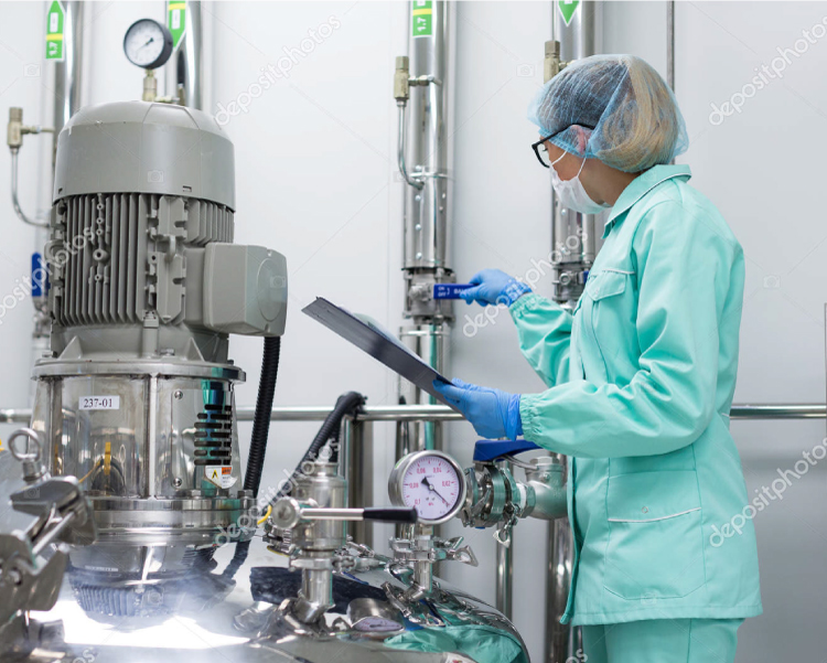22 Food safety consultant reviewing valve and gauge on a high-hygiene stainless steel reactor for infant formula production.