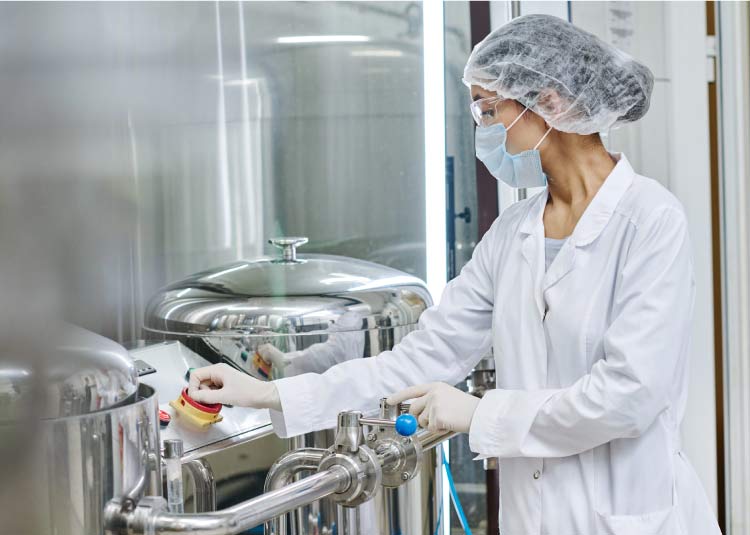 koenig-food-control Operator or auditor in a clean room operating controls on a stainless steel food-grade tank for infant formula manufacturing.